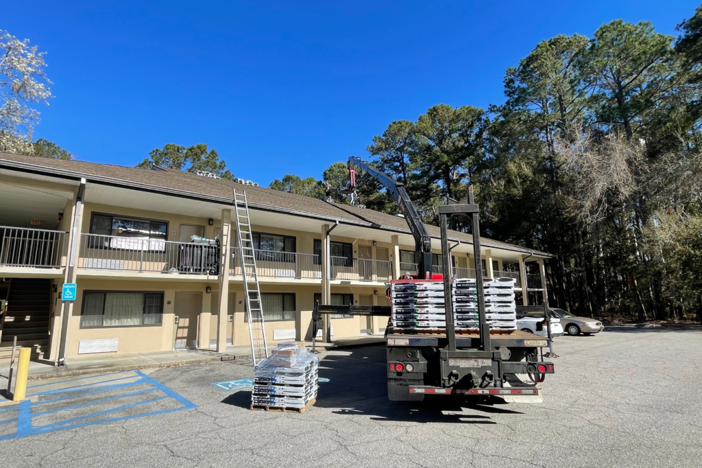 Construction company putting new roof on 2 story motel. Commercial roofing services