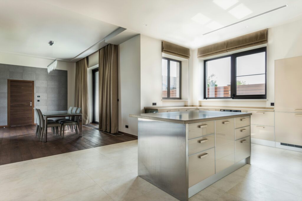 Spacious modern kitchen with minimalist design featuring sleek cabinetry and open dining area.